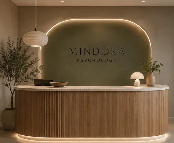 Mindora Psychology reception in Sutherland with an olive-green feature wall and curved timber desk